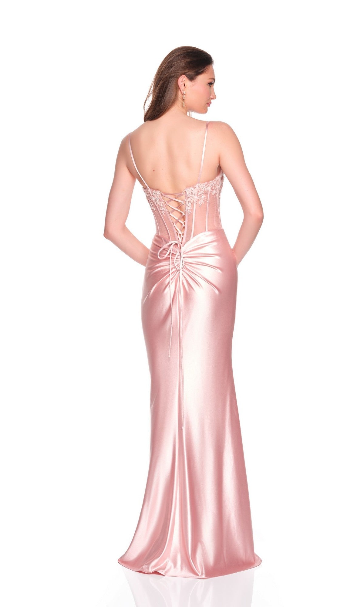 A woman models the Dave and Johnny 12669 long prom dress, featuring pink fabric, spaghetti straps, a lace-up back, and a fitted corset design, standing against a white background.
